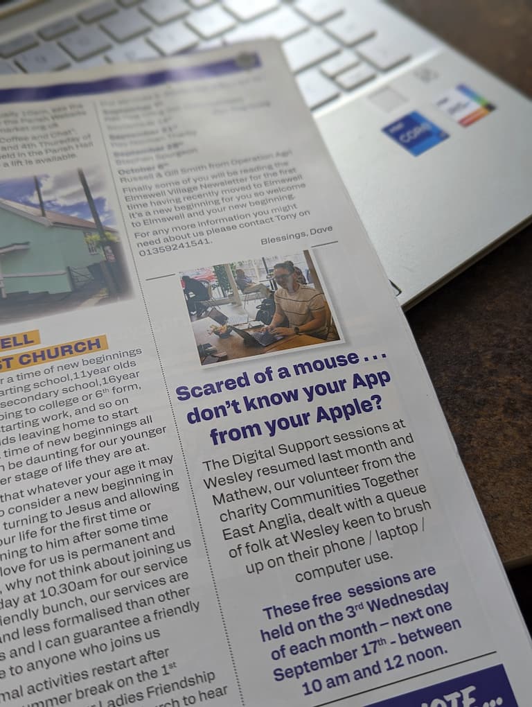 A closeup photo of magazine laying on a laptop, the page features a man smiling, sat at a laptop
